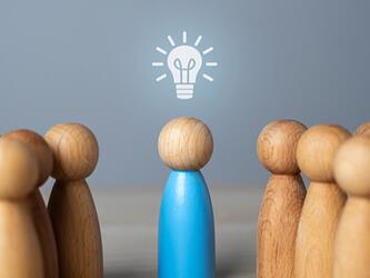 wooden block people with lightbulb graphic